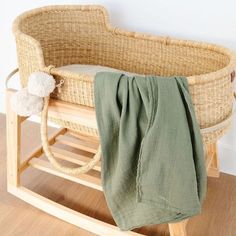 a baby crib with a blanket on it and a stuffed animal in the basket