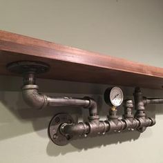 a shelf with pipes and gauges mounted to it's sides on the wall