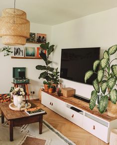 a living room filled with furniture and a flat screen tv on top of a wooden table