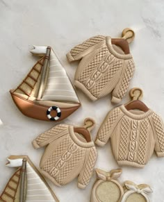 some cookies are shaped like boats and sweaters