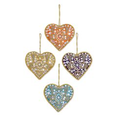 three heart shaped pendants with different colored stones on them, one in gold and the other in silver