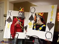 two people dressed up as playing card suits and holding cards in front of their faces