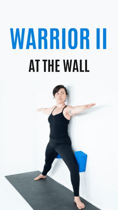 a woman standing on top of a yoga mat in front of a white wall with the words, yoga at the wall warrior ii