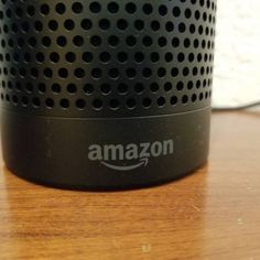 an amazon speaker sitting on top of a wooden table