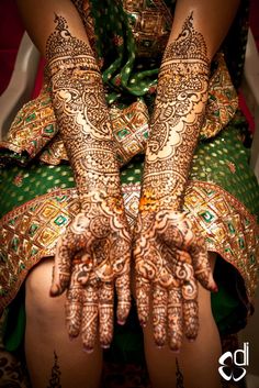 the hands and feet of a woman with henna tattoos