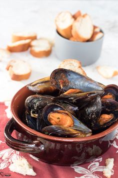 mussels in a bowl with bread on the side