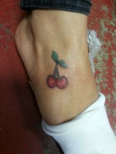 a small cherry tattoo on the ankle