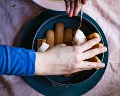 a person eating food from a plate on a table