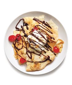 a white plate topped with an ice cream sundae next to chips and cherries