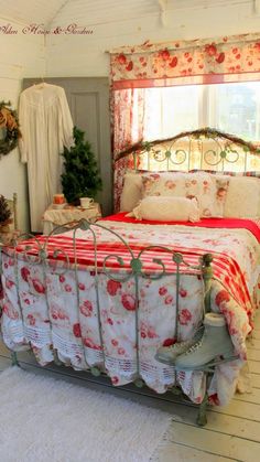 a bed with red and white bedspread in a bedroom next to a window