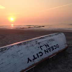 a boat sitting on top of a beach next to the ocean