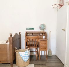 a room with a bed, desk and chair in it next to a basketball hoop