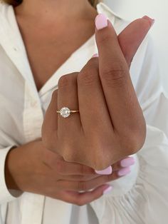 a woman wearing a diamond ring on her finger and holding the other hand with one thumb