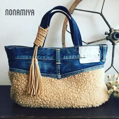 a purse made out of jeans with a tassell on the front and side