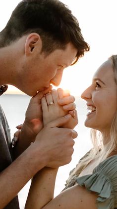 a man and woman holding each other's hands with the sun shining behind them