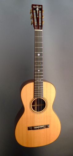 an acoustic guitar is shown against a gray background with the strings still attached to it