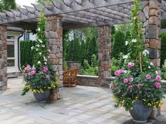 an outdoor patio with potted plants and chairs