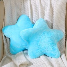 a blue star shaped pillow sitting on top of a white chair next to a stuffed animal