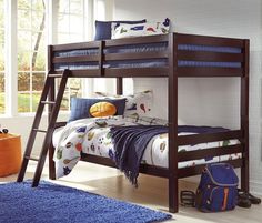 a bunk bed with a blue rug on the floor next to it and a backpack