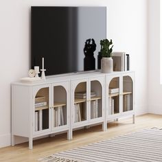 a white entertainment center with bookshelves and a flat screen tv