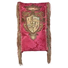 the back of a pink chair with fringes on it's legs and an ornate design