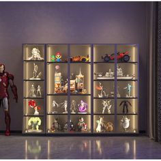 a display case filled with action figures in front of a purple wall and white walls