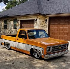 an orange and white truck parked in front of a house