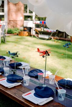 a table set up with blue plates and napkins for an airplane themed birthday party