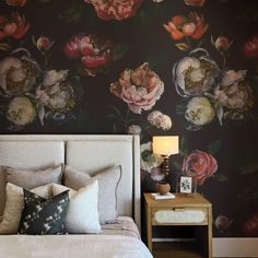 a bedroom with floral wallpaper and a bed in the foreground, along with a night stand