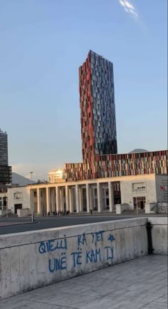 a tall building sitting next to a cement wall with graffiti on it's side