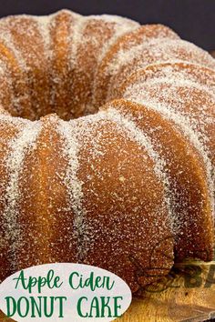 an apple cider donut cake with powdered sugar on top, sitting on a cutting board