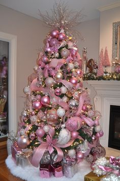 Christmas tree decorated with pink and silver ornaments, ribbons, and lights, surrounded by wrapped gifts. Pink Frosted Christmas Tree, Christmas Trees 2024 Ideas, Pink And Rose Gold Christmas Decor, Christmas Tree Character Ideas, Christmas Tree With Photos, Green Christmas Tree With Pink Decor, Pink Candy Cane Christmas Tree, Pink Candy Christmas Tree, Pink Decorated Christmas Tree