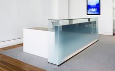 a glass counter in an empty room with wood flooring and white walls on the wall