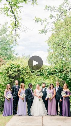 a group of people standing next to each other on top of a cement slab in front of trees