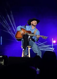 a man with a guitar on stage at a concert