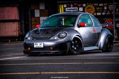 a small gray car parked in front of a store