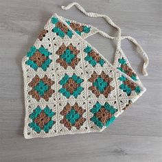 two crocheted bags sitting on top of a wooden table