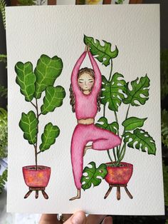 a person holding up a card with plants on it