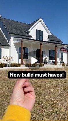 someone holding their thumb up in front of a white house with the words new build must haves