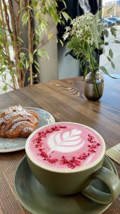 a cup of cappuccino with powdered sugar on top and a pastry