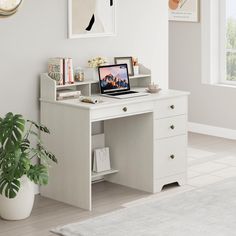 a white desk with a laptop on top of it next to a potted plant