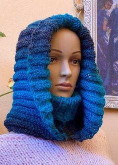 a mannequin's head wearing a knitted blue scarf and cowl