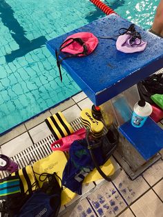 a blue table sitting next to a swimming pool filled with flip flops and water bottles