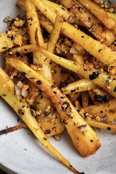 a white plate topped with french fries covered in seasoning