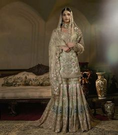 a woman in a wedding dress standing next to a bed