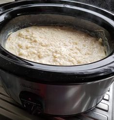 a crock pot filled with food sitting on top of an oven