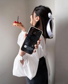 a woman holding an iphone in her right hand