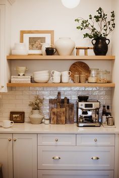 a kitchen with white cabinets and open shelves