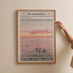 a woman is holding up a poster in front of her face, with the caption salt water heals everything