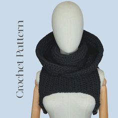 a mannequin wearing a black knitted scarf on top of a white dummy